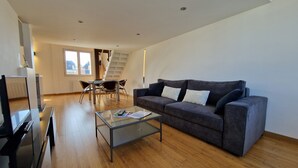 Una sala de estar moderna con sofá, mesa de centro y comedor.