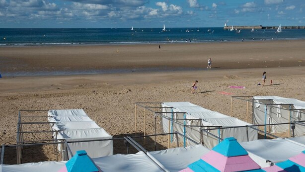Une plage avec des tentes et un ciel dégagé.