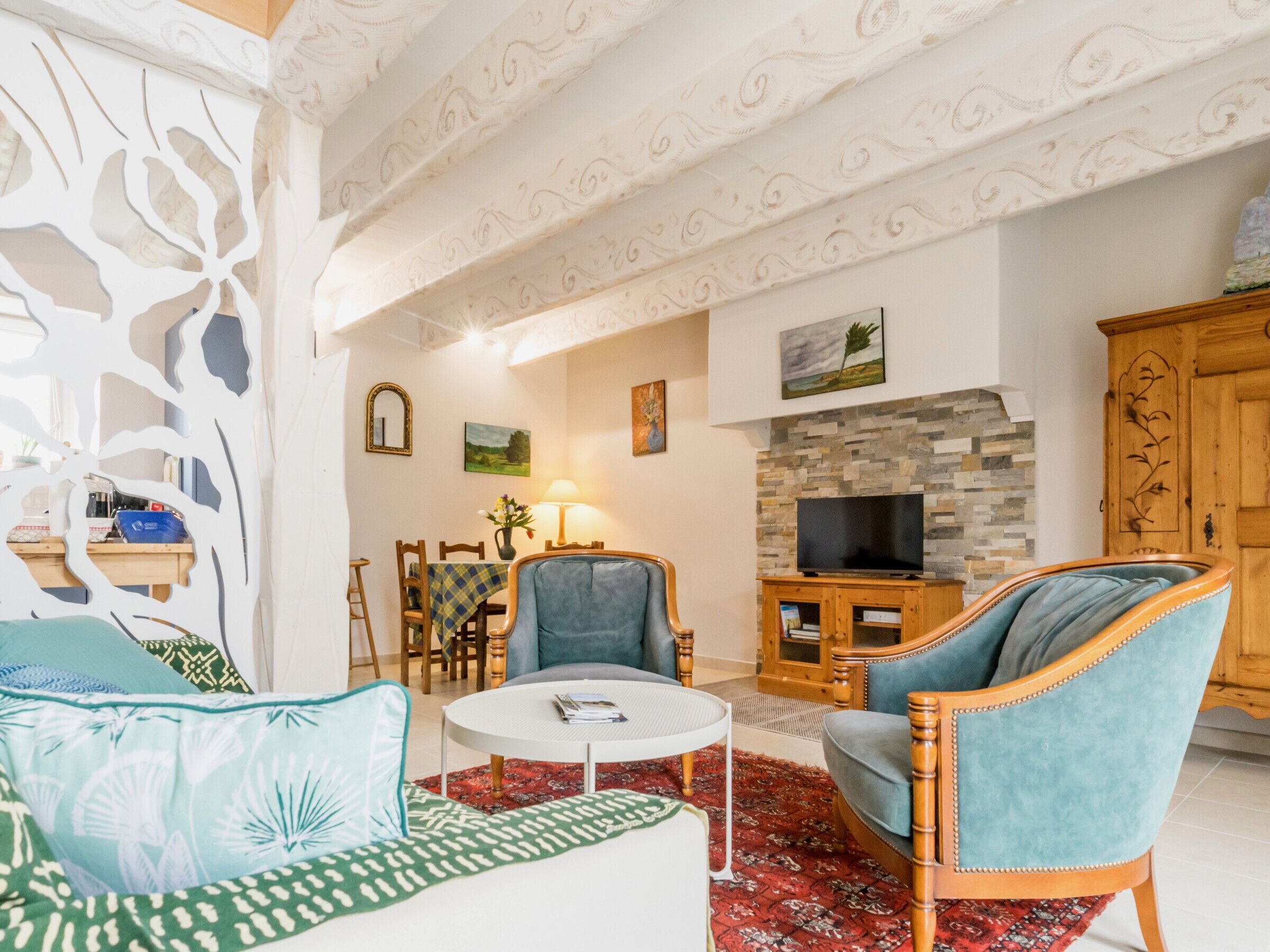 Un salon comprenant un canapé, des fauteuils, une table basse, un téléviseur et une cheminée.
