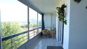 Ein Balkon mit Blick auf eine Stadtlandschaft, einem Tisch und zwei Stühlen.