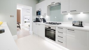 A modern kitchen with white cabinetry, a Bosch oven, a microwave, and a toaster. - Classy 2BR 2BA in the ♥️ of Central London ❄️ Air Con. 🌿 Terrace | Sleeps 6 (Greater London)