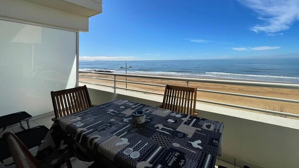 A balcony with a table and chairs overlooking a beach. - One-bedroom apartment with terrace, AC and parking in Capbreton (Capbreton)