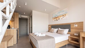 Una habitación de hotel moderna con una cama, un escritorio y una escalera.