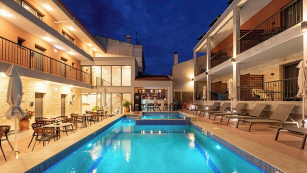 Una piscina interior con sillas de descanso y zona de bar.
