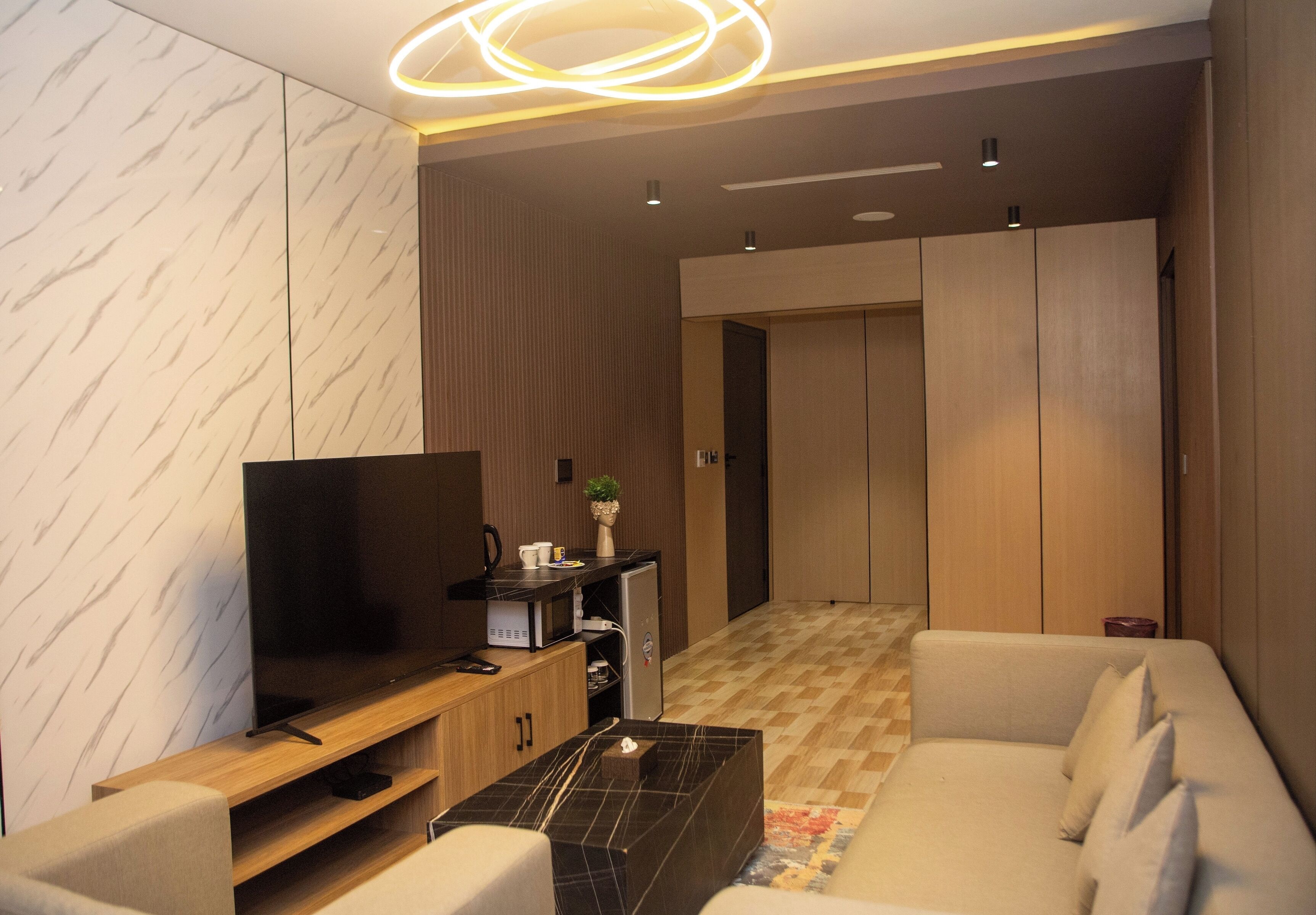 Una sala de estar moderna con una televisión de pantalla plana, una mesa de centro, un sofá y un armario.