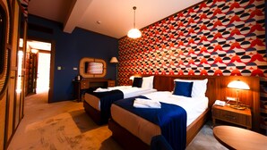A hotel room with two beds, a desk, a chair, and a patterned wall. - 74 Hotel (Antalya)