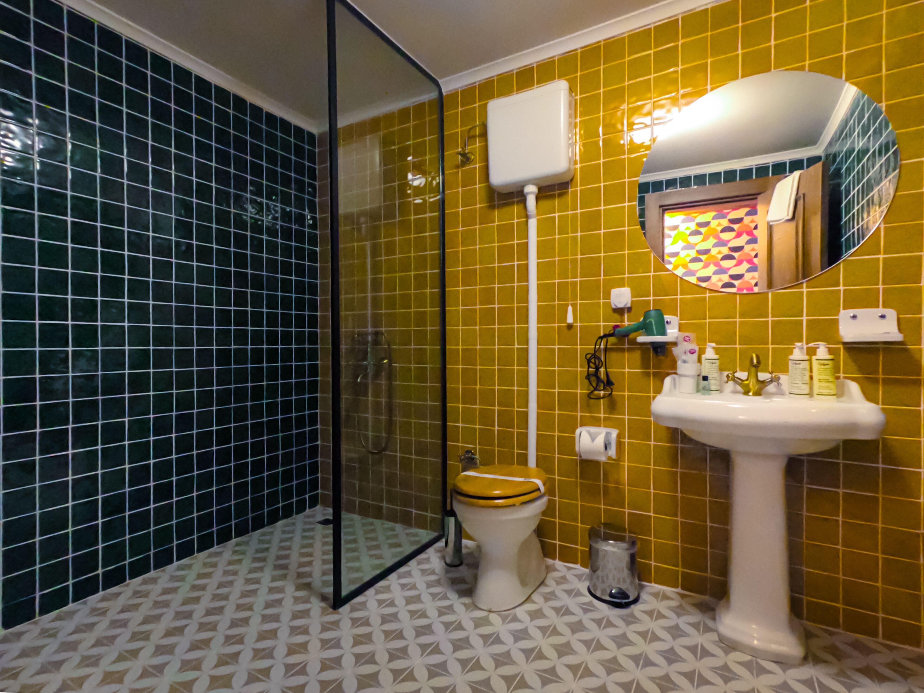 A bathroom with a toilet, sink, and shower.