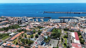 Stunning coastal town with a marina and historic church, surrounded by scenic coastline views.