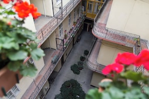 A multi-level courtyard with balconies, potted plants, and a central pathway. - Lovely Apartment by National Museum (Budapest)