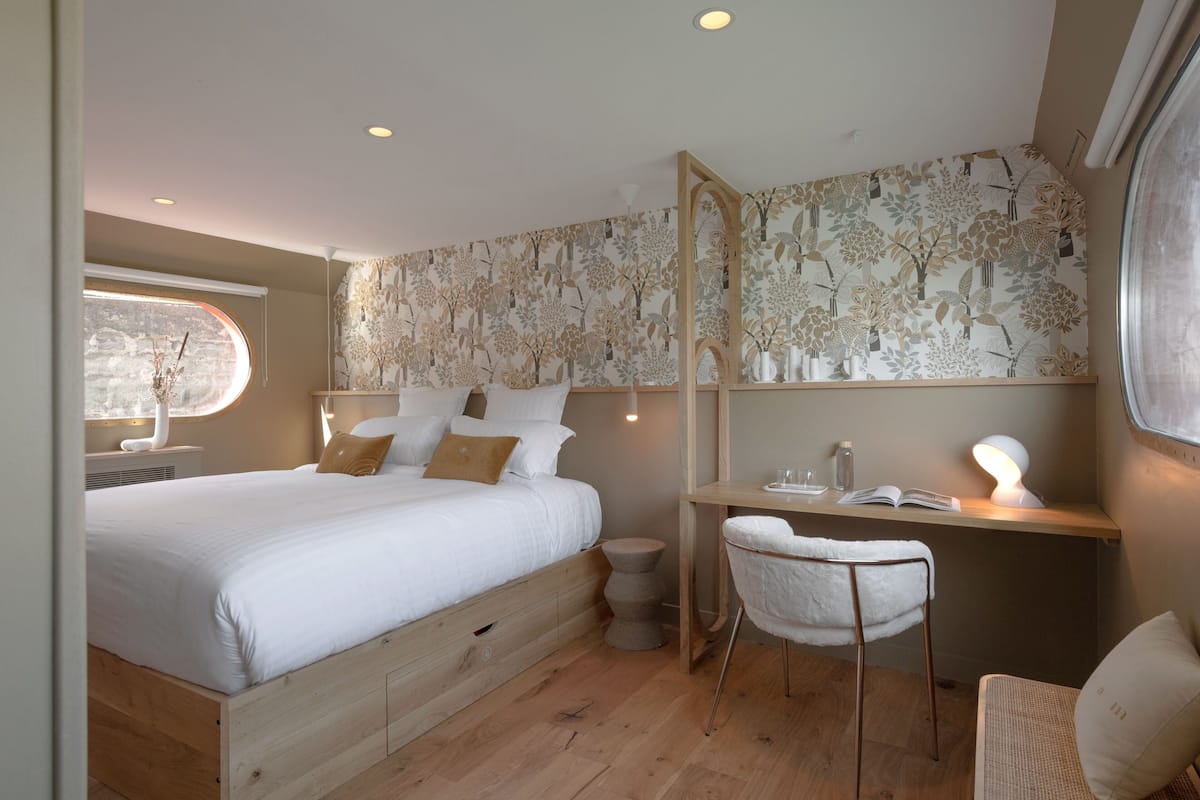 Une chambre à coucher avec un lit, un bureau, une chaise et une fenêtre.