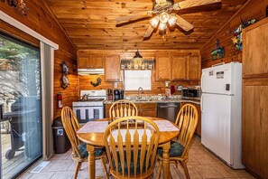 Kitchen features a central island, dining table for four, and modern appliances.