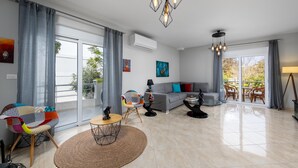 A spacious living room with a sofa, chairs, a coffee table, and a dining area.
