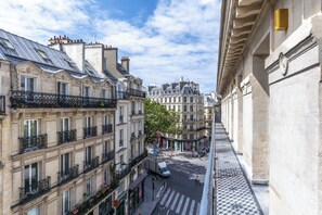 A narrow street flanked by historic buildings with balconies and a pedestrian crossing. - Aparthotel Quartier Libre Marais (Paris)