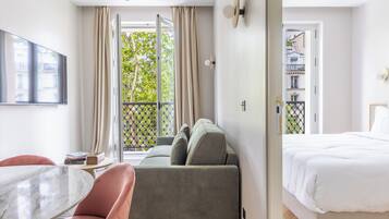 Una moderna camera d'albergo con un divano, un letto, un tavolino in marmo e vista sull'esterno.