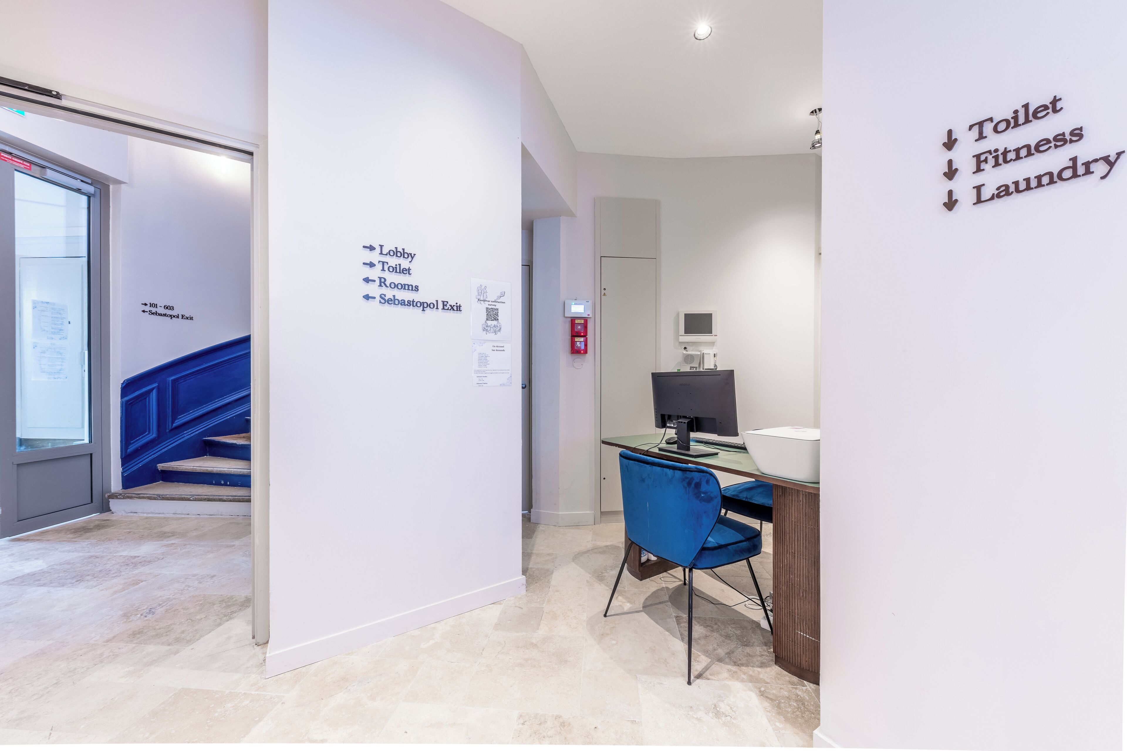 A hallway with directional signs to the lobby, toilet, and laundry.