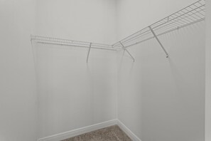 A corner of a room with a white wall and a corner shelf unit.