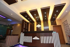 A reception desk with a modern design, featuring a logo and a series of vertical light fixtures. - Nagar Valley Hotel Ltd. (Dhaka)