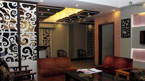 A modern lobby with a sofa, chairs, and a coffee table. - Nagar Valley Hotel Ltd. (Dhaka)