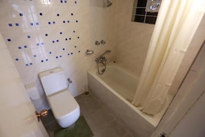 A bathroom with a toilet, a bathtub, and a shower. - Nagar Valley Hotel Ltd. (Dhaka)