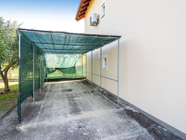 A covered outdoor area with a concrete floor, metal frame, and green netting. - Holiday Home Villa Vesna Lux (Policnik)
