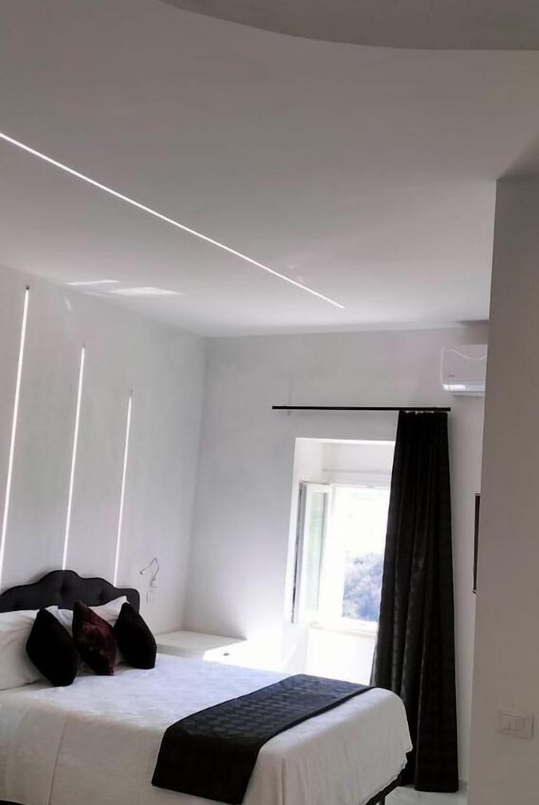 Ein modernes Hotelzimmer mit Bett, Fenster und Vorhang.