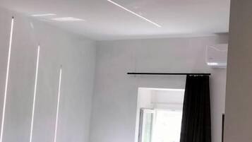 Ein modernes Hotelzimmer mit Bett, Fenster und Vorhang.