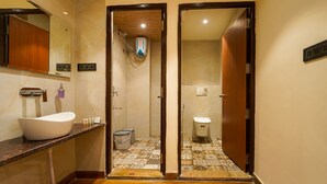 Un bany amb un lavabo blanc, una dutxa i un vàter.