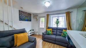 A living room with two grey sofas, a small white table, and a window with curtains. - I Luv London Too! 1bed Stunnin Home Sleeps 3! (London)
