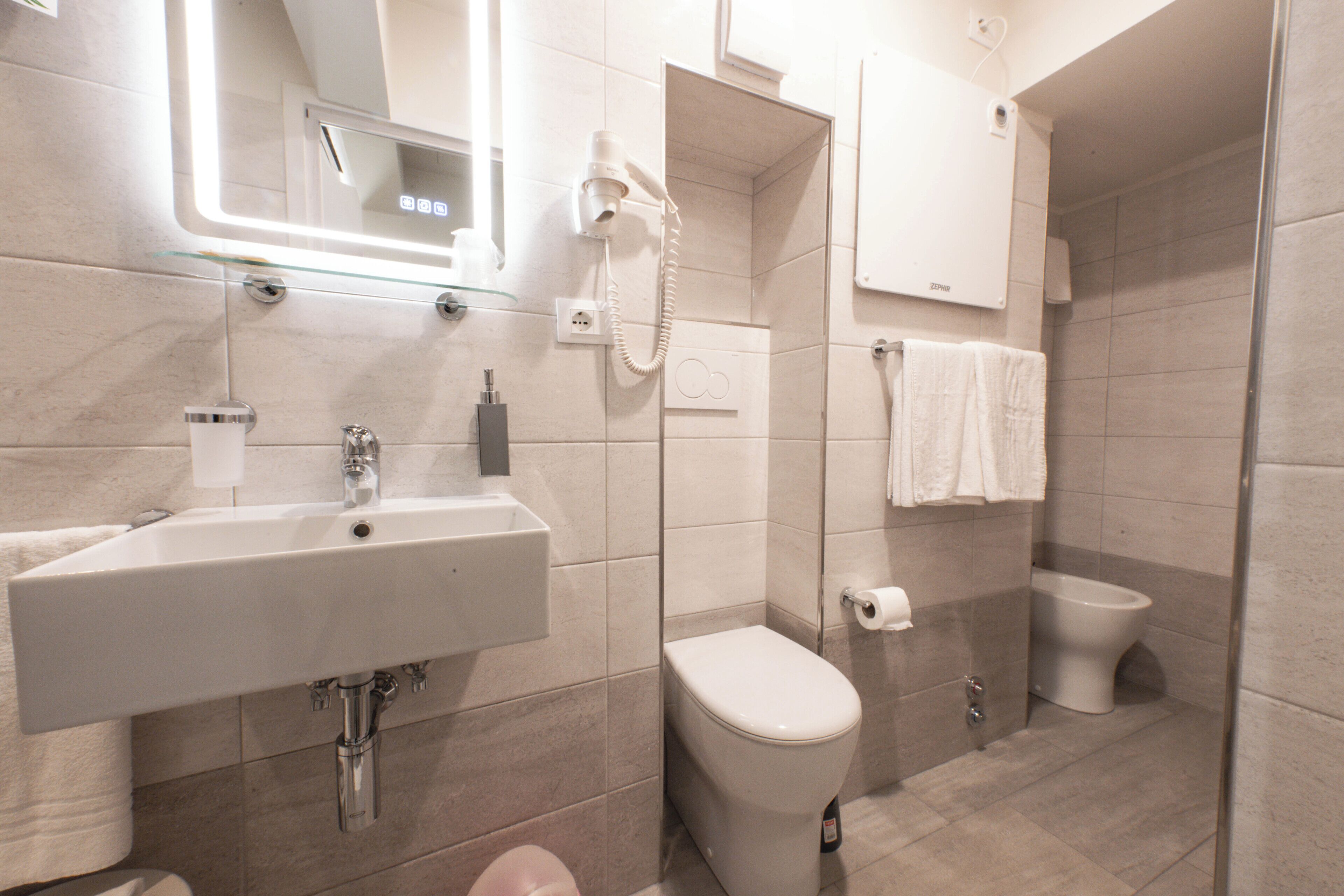 Ein modernes Badezimmer mit Waschbecken, Toilette und Dusche.