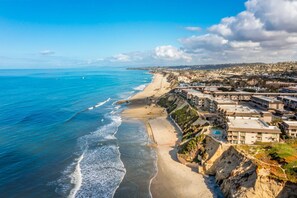 A coastal hotel with a beach view, multiple buildings, and a rocky shoreline. - Del Mar Beach Club Condo with Ocean Views & Pool (Solana Beach)