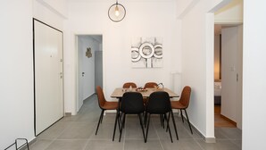 Uma sala de jantar com mesa, cadeiras e um lustre.