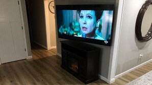 Ein Flachbildfernseher an der Wand über einem Kamin.