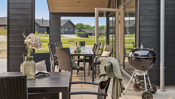 An outdoor patio with wicker furniture, a grill, and a view of the surrounding area. - Nice home in Sydals with sauna (Sydals)