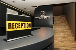 Un mostrador de recepción con un letrero que dice 'RECEPTION' y una escalera que conduce a un nivel superior.