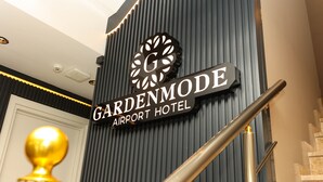 A sign for Gardenmode Airport Hotel with a modern design and a staircase. - Garden Mode Airport Hotel (Arnavutköy)