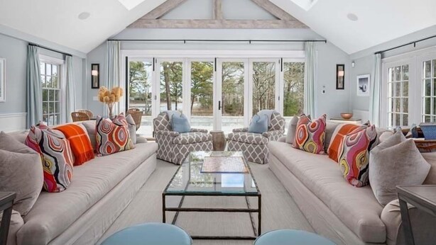 A spacious living room with a high ceiling, large windows, and a central coffee table. - The Ultimate Cape Cod luxury home. Dock, pool, hot tub and views! RPMS104 (Osterville)