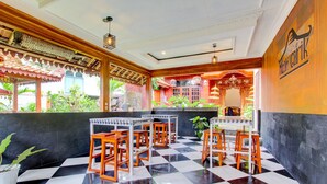 Een restaurant met geruit vloerkleed, houten tafels en stoelen.