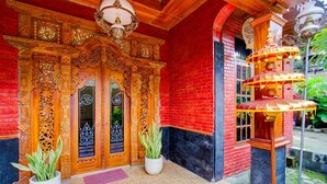 Un bâtiment traditionnel avec des portes en bois richement décorées et un mur en briques rouges.