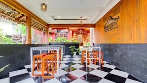 Een restaurant met geruite vloer, houten tafels en stoelen.