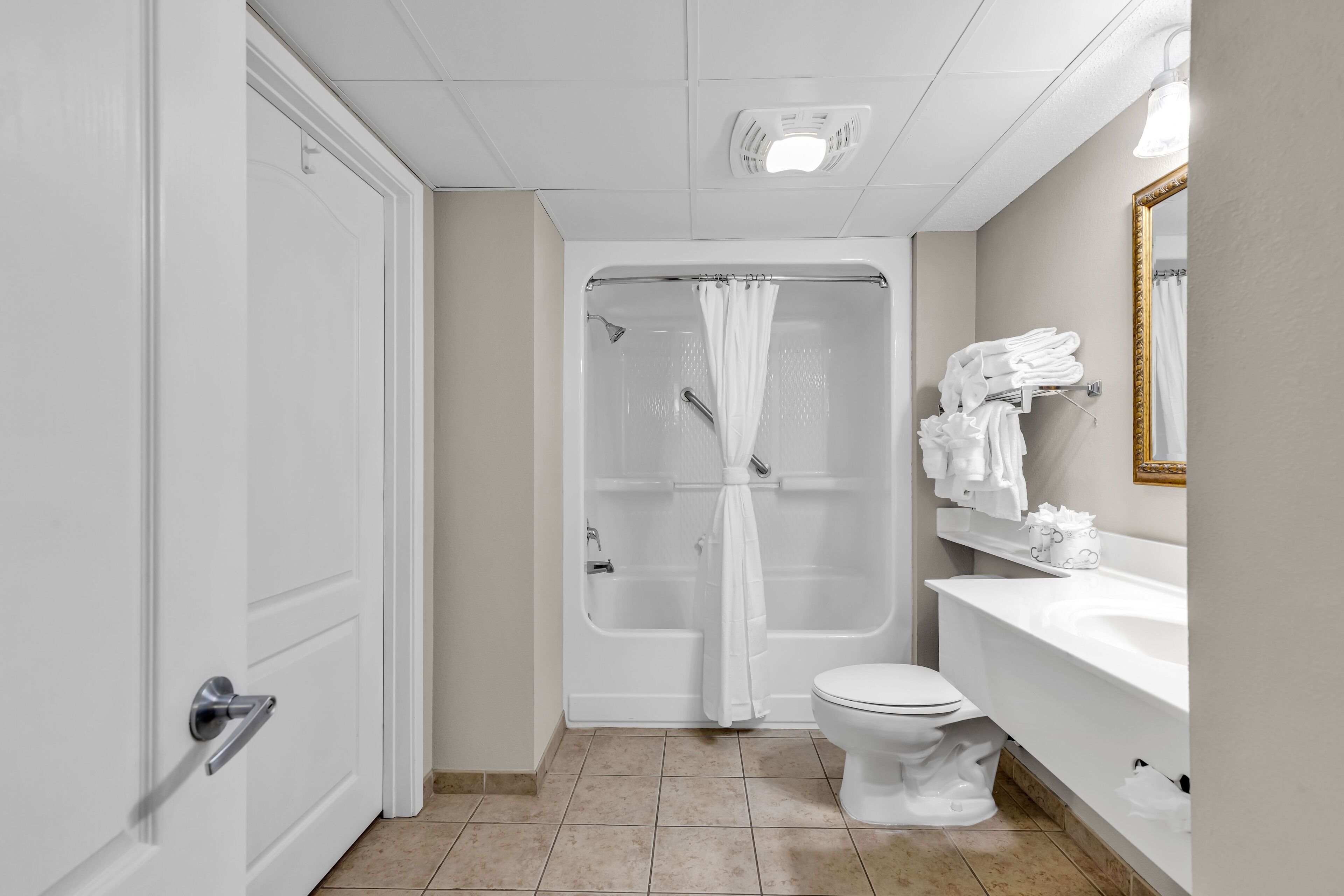 Une salle de bain avec douche, toilettes et lavabo.