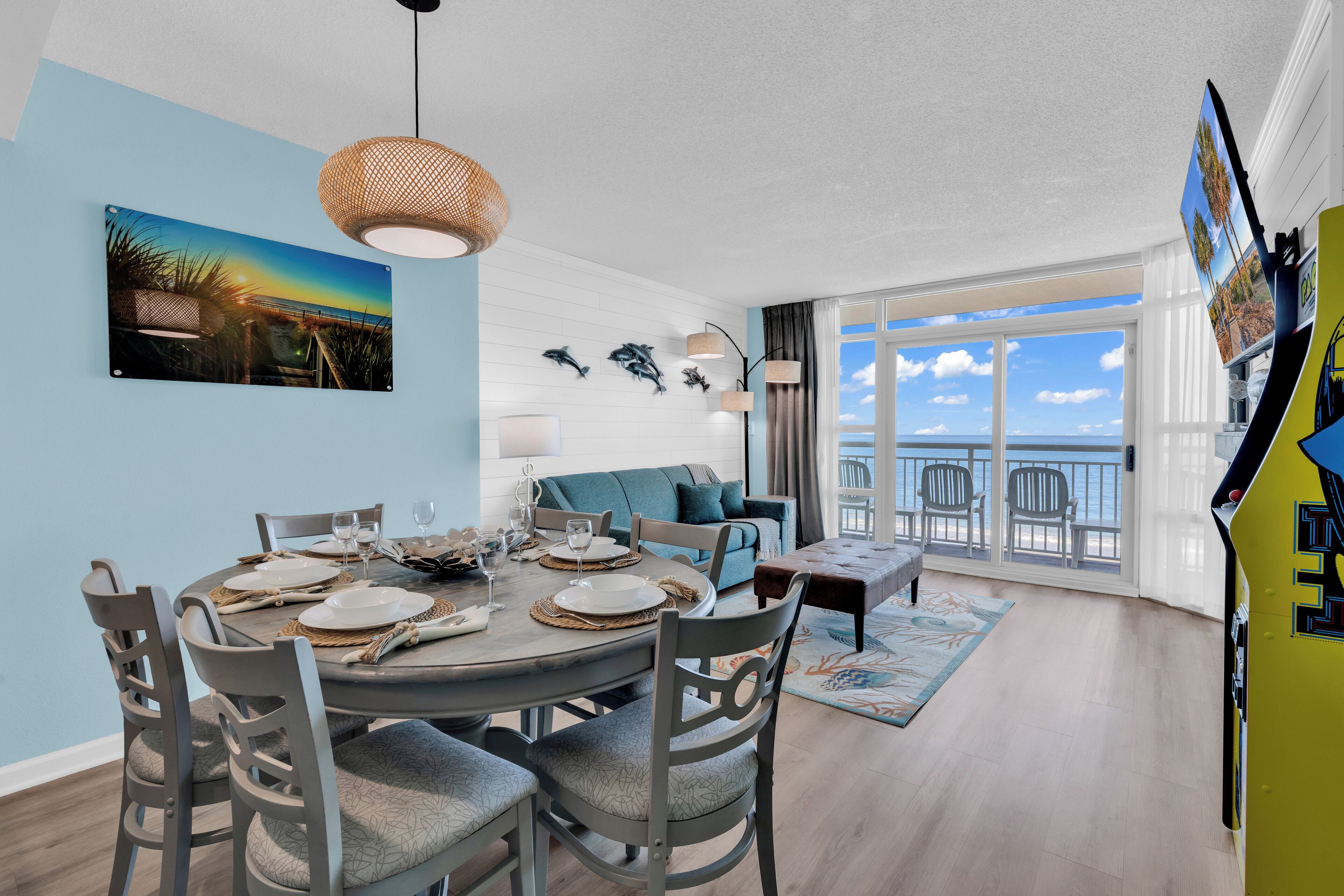 Un coin repas avec une table ronde pour quatre personnes, un canapé et un balcon avec vue.
