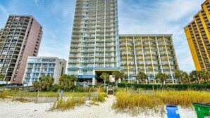 A high-rise hotel with multiple floors, a central entrance, and a beach view. - Carolinian Resort (Myrtle Beach)