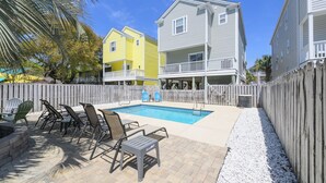 A backyard with a swimming pool, patio furniture, and a wooden fence. - Walk to the Beach 5 BR Beach House with a Private Pool! Catching R.A.E.S (Surfside Beach)