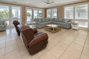 A spacious living room with a leather sofa, a grey sectional, and a coffee table.