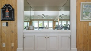 A kitchen with a large window, wooden paneling, and a ceiling fan. - Oceanfront 7 BR Beach House with a Private Pool! Crown Jewel  (Garden City)