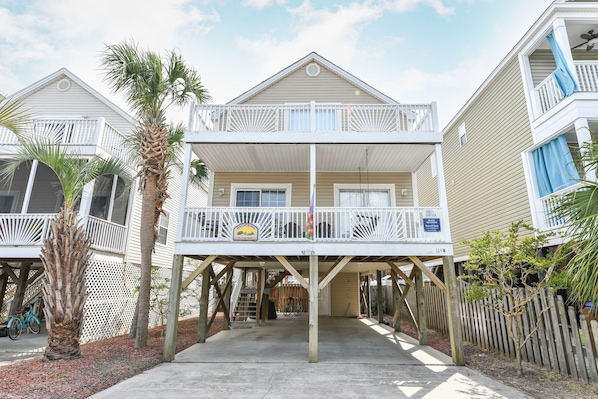 Enjoy the ocean views from the upper-level balcony of this beachfront property, featuring a simple design and a small porch area.