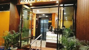 Een hotelingang met een receptiebalie, waarop 