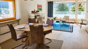 A dining area with a round table, chairs, and hanging pendant lights.