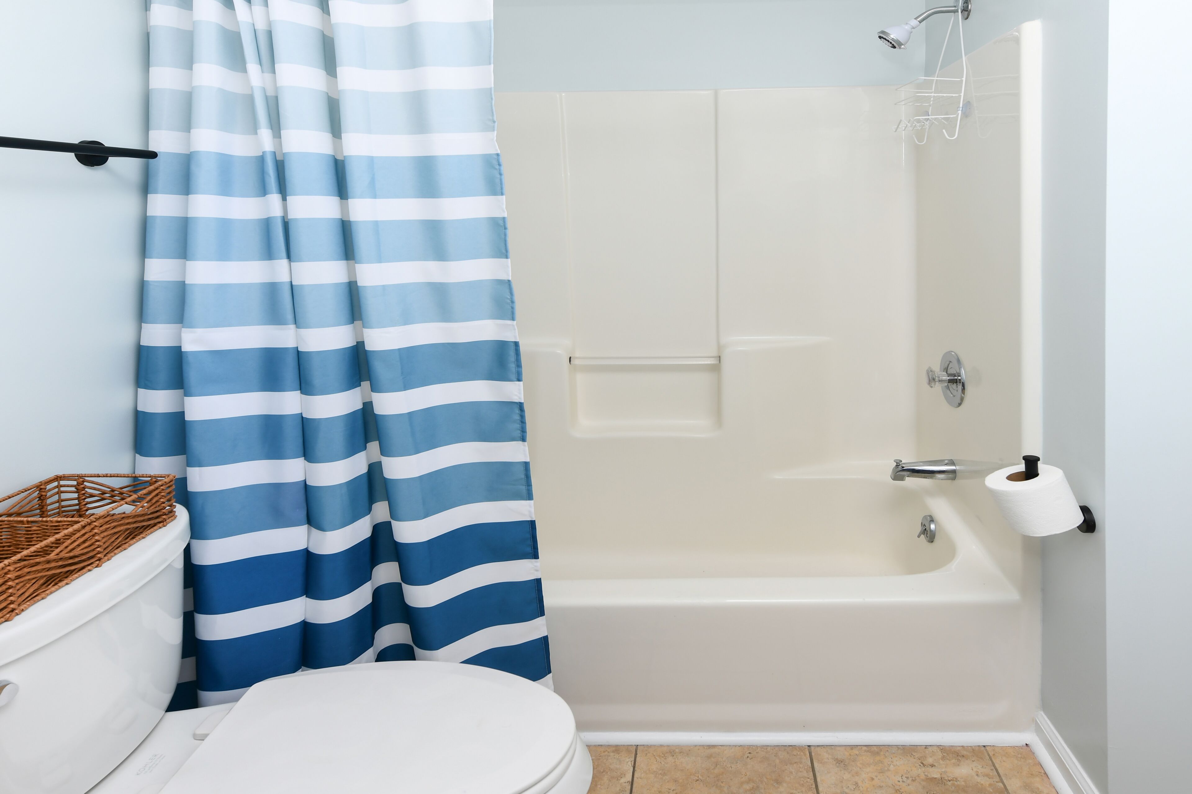 Un baño con bañera, inodoro y cortina de ducha.