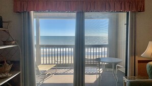 A room with a sliding glass door leading to a balcony with a view of the ocean. - Oceanfront 2 BR Condo with a Shared Pool! Sea Shadow 402   (Surfside Beach)